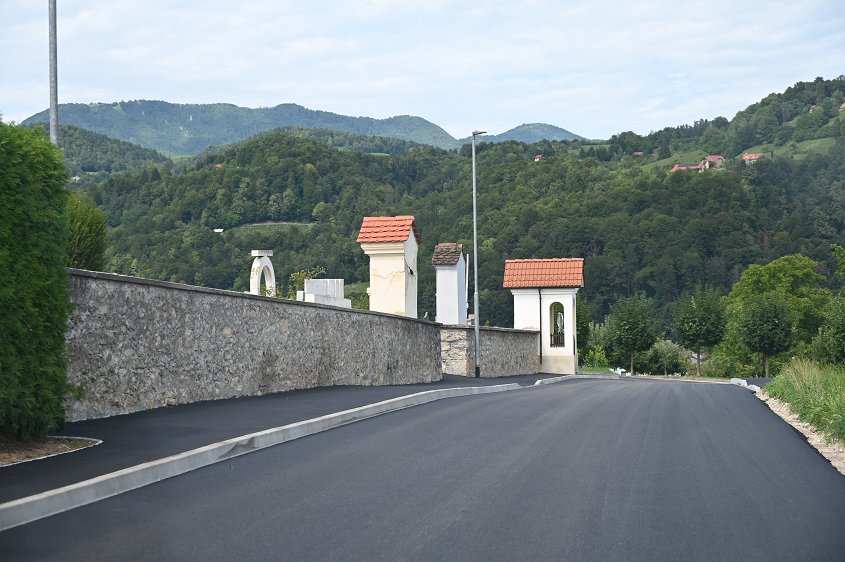 Na fotografiji je na novo asfaltirana in razširjena lokalna cesta pri boštanjskem pokopališču. 