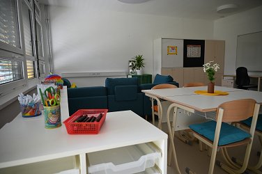 Fotografija učnega stanovanja, pripravljen je material za ustvarjanje, barvice, flomastri, škarje ipd. 