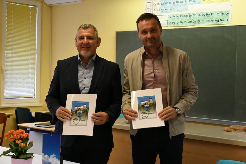 Na fotografiji sta z leve proti desni župan Srečko Ocvirk in direktor podjetja Gradnje d. o. o. Jernej Povše, oba držita občinski mapi, v kateri so podpisane pogodbe za gradnjo novega šolskega športnega igrišča na Blanci. 